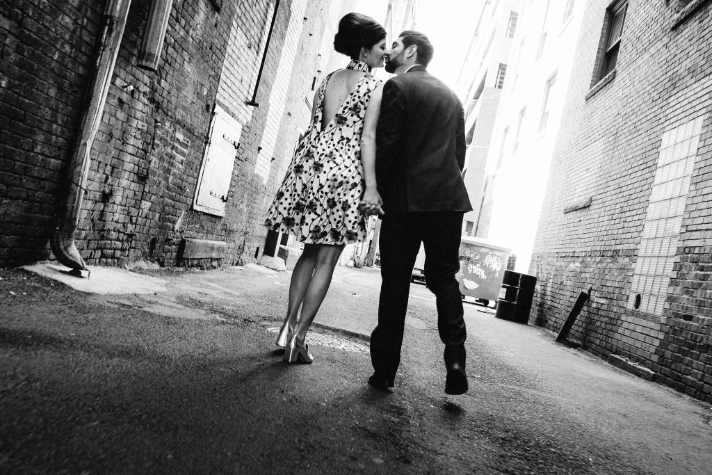 Mad Men inspired engagement shoot bride and groom kissing in alley