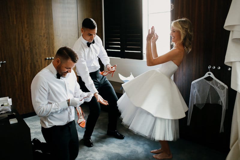 bride putting on red shoes