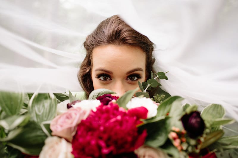vintage forest styled shoot bride under veil with bouquet