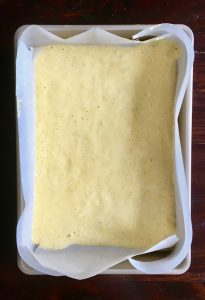 Genoise sponge mixture in baking tin with parchment paper