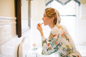1940s Inspired Countryside Wedding bride finger curls bride putting on lipstick